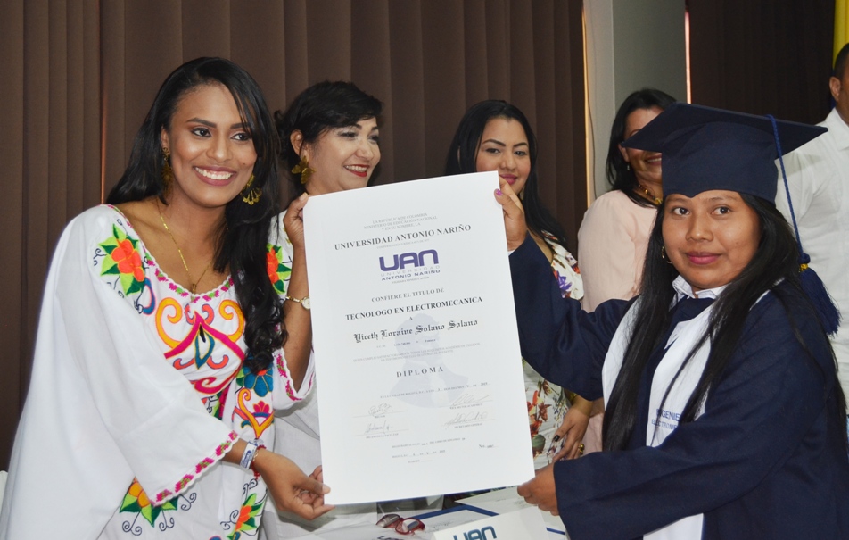 La coordinadora de bienestar estudiantil, Blanca Paola González, le hace entrega título de profesional a Loraine Yiceth Solano.