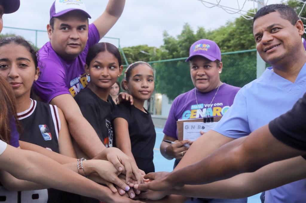 Un grupo de niñas en compañía de Genaro Redondo realizando una charla motivacional previo a un partido de baloncesto.