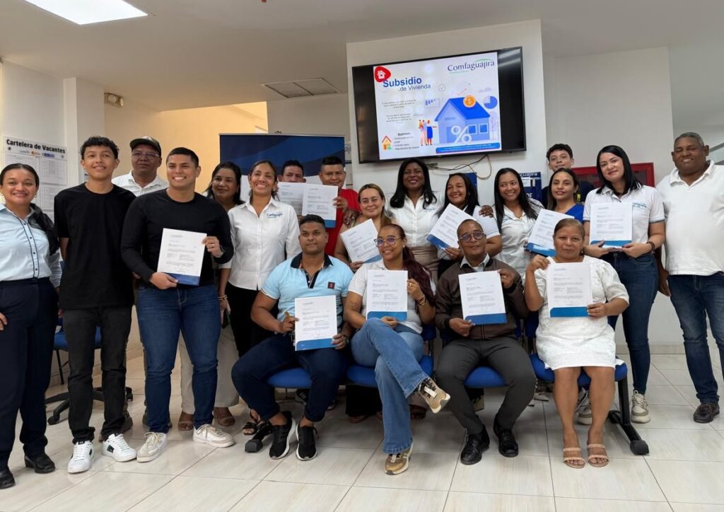 La directora administrativa de Comfaguajira, Diana Tello Córdoba, junto a varios de los hogares beneficiados durante la entrega de subsidios de vivienda en La Guajira.